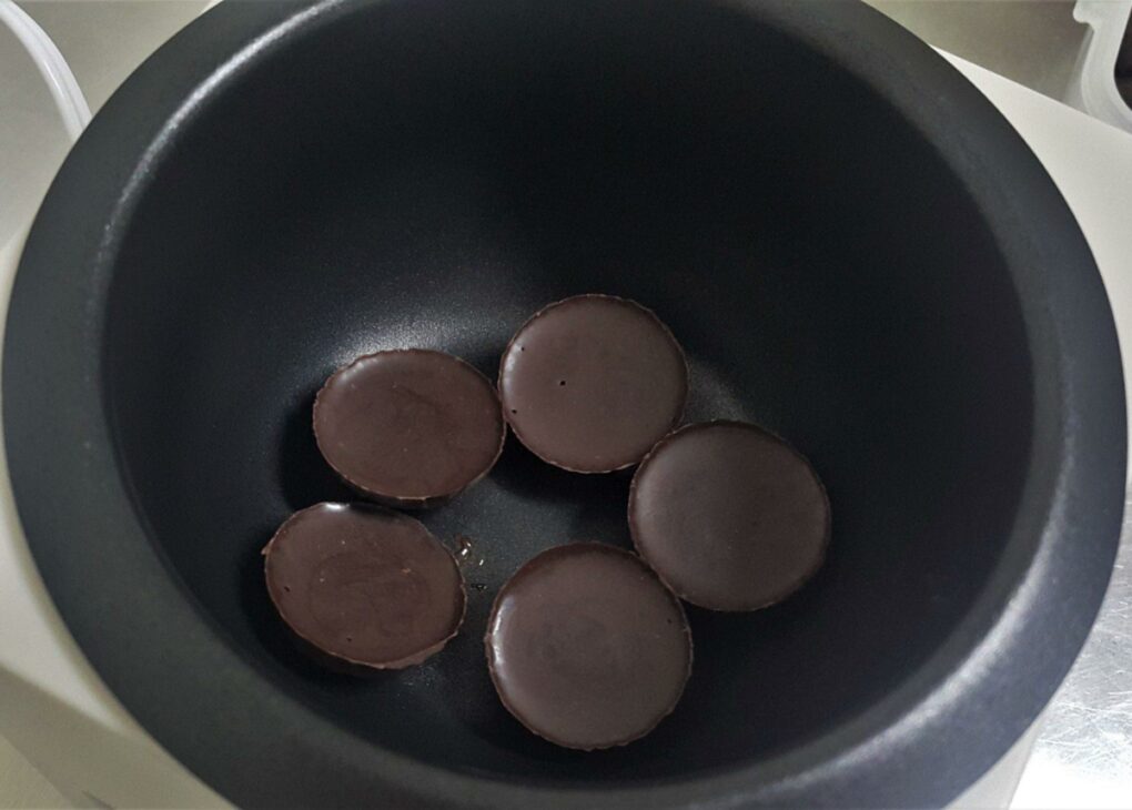 five pieces of chocolate melted in the instant pot on a tabletop.