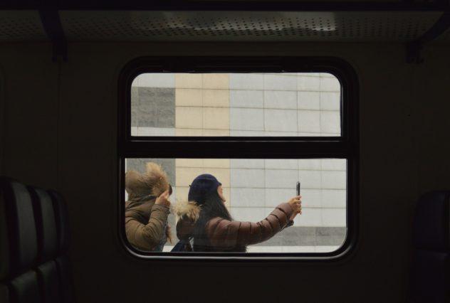 Girl Taking Selfie Through Train Window