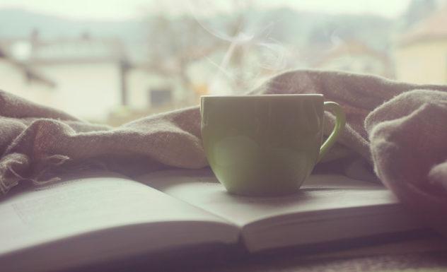white cup of coffee on top of book